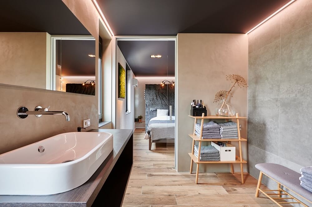 Plameco Spanndecke: Alternative zu Gipskarton. Badezimmer mit dunkler Zimmerdecke und umlaufender LED-Beleuchtung